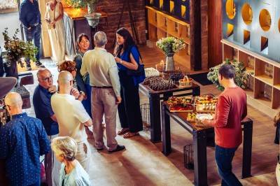 Façade en pierre éclairée d'une bâtisse ancienne avec une enseigne lumineuse, vue de nuit.