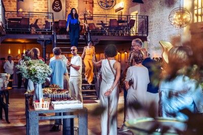 Façade en pierre éclairée d'une bâtisse ancienne avec une enseigne lumineuse, vue de nuit.