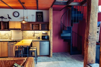 Façade en pierre éclairée d'une bâtisse ancienne avec une enseigne lumineuse, vue de nuit.