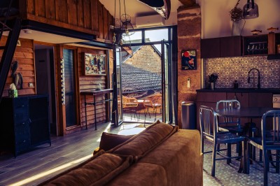 Façade en pierre éclairée d'une bâtisse ancienne avec une enseigne lumineuse, vue de nuit.