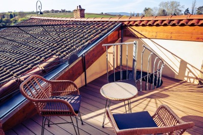 Façade en pierre éclairée d'une bâtisse ancienne avec une enseigne lumineuse, vue de nuit.