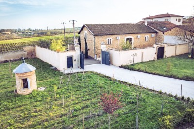 Façade en pierre éclairée d'une bâtisse ancienne avec une enseigne lumineuse, vue de nuit.
