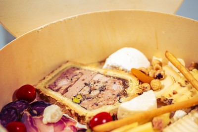 Façade en pierre éclairée d'une bâtisse ancienne avec une enseigne lumineuse, vue de nuit.