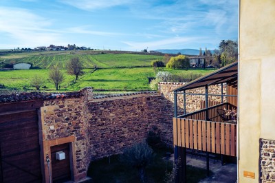 Façade en pierre éclairée d'une bâtisse ancienne avec une enseigne lumineuse, vue de nuit.