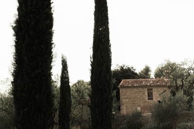 Façade d'un bâtiment en pierre éclairée la nuit, entourée de végétation sombre.