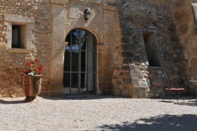 Façade d'un bâtiment en pierre éclairée la nuit, entourée de végétation sombre.