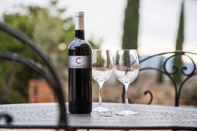 Façade d'un bâtiment en pierre éclairée la nuit, entourée de végétation sombre.