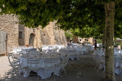 Façade d'un bâtiment en pierre éclairée la nuit, entourée de végétation sombre.