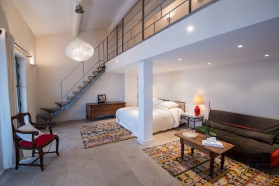 Façade d'un bâtiment en pierre éclairée la nuit, entourée de végétation sombre.