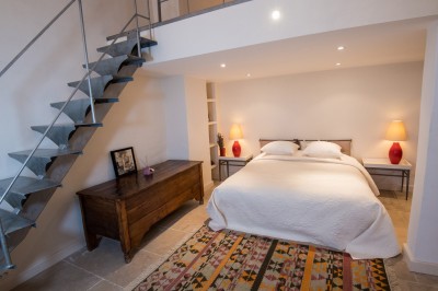 Façade d'un bâtiment en pierre éclairée la nuit, entourée de végétation sombre.