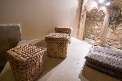 Façade d'un bâtiment en pierre éclairée la nuit, entourée de végétation sombre.