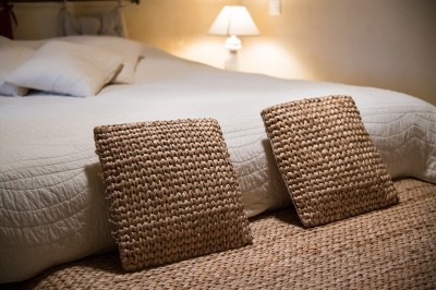 Façade d'un bâtiment en pierre éclairée la nuit, entourée de végétation sombre.