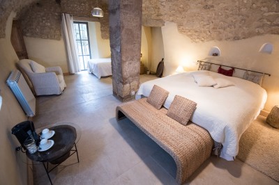 Façade d'un bâtiment en pierre éclairée la nuit, entourée de végétation sombre.