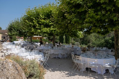 Façade d'un bâtiment en pierre éclairée la nuit, entourée de végétation sombre.
