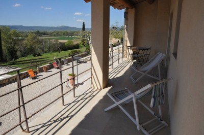 Façade d'un bâtiment en pierre éclairée la nuit, entourée de végétation sombre.