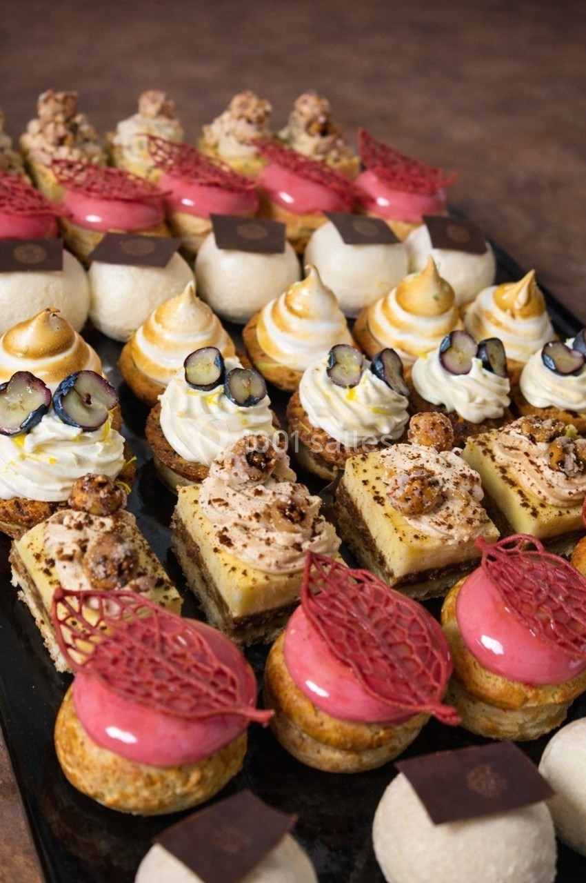 Plateau de pâtisseries variées comprenant entremets, choux garnis, tartelettes et desserts décorés de fruits et crèmes.