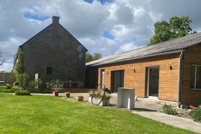 Cuisine professionnelle avec équipements en acier inoxydable, comprenant un four, des étagères et des plans de travail.