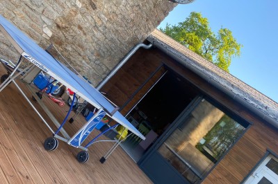 Cuisine professionnelle avec équipements en acier inoxydable, comprenant un four, des étagères et des plans de travail.