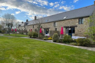 Cuisine professionnelle avec équipements en acier inoxydable, comprenant un four, des étagères et des plans de travail.