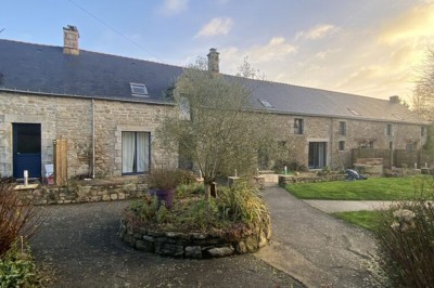 Cuisine professionnelle avec équipements en acier inoxydable, comprenant un four, des étagères et des plans de travail.