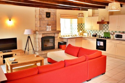 Cuisine professionnelle avec équipements en acier inoxydable, comprenant un four, des étagères et des plans de travail.