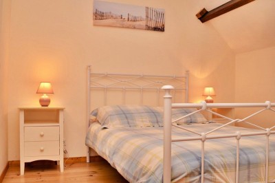 Cuisine professionnelle avec équipements en acier inoxydable, comprenant un four, des étagères et des plans de travail.