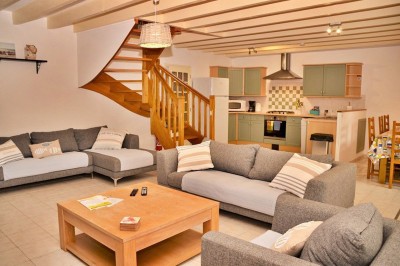 Cuisine professionnelle avec équipements en acier inoxydable, comprenant un four, des étagères et des plans de travail.