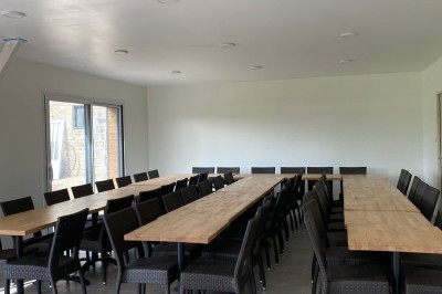 Jardin verdoyant avec pelouse, arbres dénudés, fleurs printanières et ciel bleu parsemé de nuages légers.
