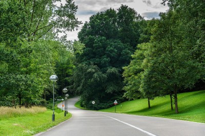 Femme assise dans un hammam aux carreaux roses, enveloppée dans une serviette blanche.