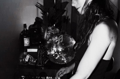 Femme utilisant une console de mixage dans un environnement intérieur, avec une boule à facettes en arrière-plan.