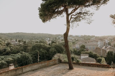 Des personnes se servent à un buffet en plein air, disposé sur une longue table devant un mur en pierre.