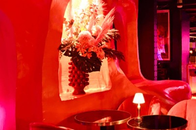 Miniature Location salle Paris 1 (Paris) - Louvre 66 #6 Assiette de brochettes et plat de poisson avec deux cocktails sur une table, fond rouge tamisé.