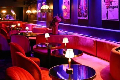 Miniature Location salle Paris 1 (Paris) - Louvre 66 #3 Assiette de brochettes et plat de poisson avec deux cocktails sur une table, fond rouge tamisé.