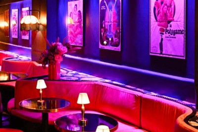 Miniature Location salle Paris 1 (Paris) - Louvre 66 #7 Décor intérieur avec fauteuils rouges, tables noires et un vase fleuri éclairé par une lumière tamisée.