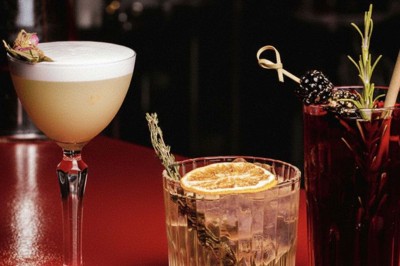 Miniature Location salle Paris 1 (Paris) - Louvre 66 #4 Décor intérieur avec fauteuils rouges, tables noires et un vase fleuri éclairé par une lumière tamisée.