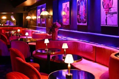 Miniature Location salle Paris 1 (Paris) - Louvre 66 #3 Décor intérieur avec fauteuils rouges, tables noires et un vase fleuri éclairé par une lumière tamisée.