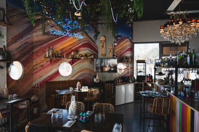 Table de restaurant avec bougie fondue allumée, verres à vin et serviette pliée, ambiance chaleureuse et tamisée.