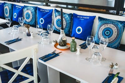 Table de restaurant avec bougie fondue allumée, verres à vin et serviette pliée, ambiance chaleureuse et tamisée.