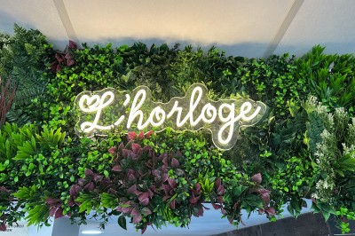 Buffet varié avec mini-burgers, samoussas, brochettes, fromages et pâtisseries, disposé sur une table près d'une baie vitrée.