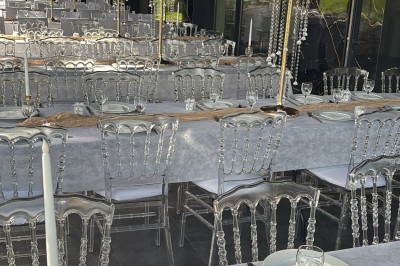 Buffet varié avec mini-burgers, samoussas, brochettes, fromages et pâtisseries, disposé sur une table près d'une baie vitrée.