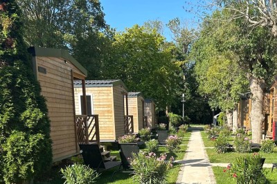 Sanitaires modernes avec cabines fermées, lavabo, carrelage clair et lumière naturelle provenant d'une fenêtre et d'un puits…
