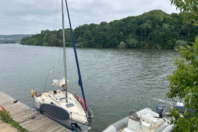 Sanitaires modernes avec cabines fermées, lavabo, carrelage clair et lumière naturelle provenant d'une fenêtre et d'un puits…