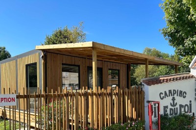 Sanitaires modernes avec cabines fermées, lavabo, murs en carrelage clair et lumière naturelle provenant d'une fenêtre et d…