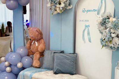 Lustre en cristal suspendu dans une cage d'escalier lumineuse avec vue sur un jardin et des bâtiments à travers une grande…