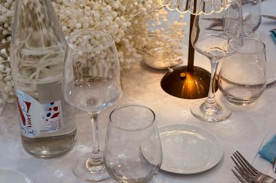 Lustre en cristal suspendu dans une cage d'escalier lumineuse avec vue sur un jardin et des bâtiments à travers une grande…