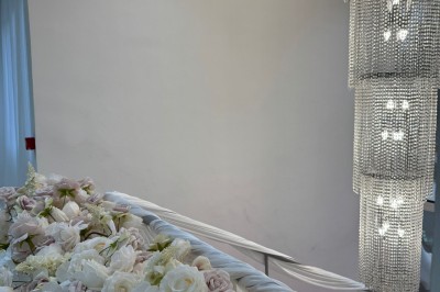 Miniature Location salle Sarcelles (Val-d'Oise) - Villa Réception #4 Salle lumineuse avec canapé gris, miroir mural, rideaux roses, étagères décorées et mobilier moderne.