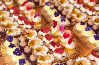 Plateau à trois étages avec fraises et morceaux de fruits, accompagné d'une fontaine de chocolat sur une table.