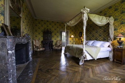 Salle lumineuse avec grandes baies vitrées, tables rondes en métal et lustres suspendus sous un plafond décoré.
