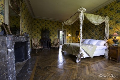 Un groupe de femmes en robes élégantes réagit avec joie face à une mariée dans une pièce décorée.