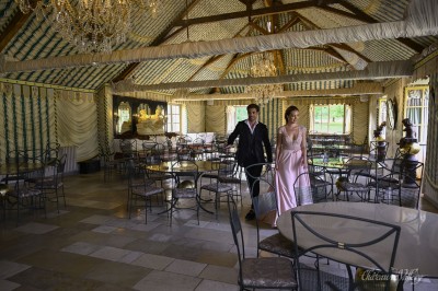 Un groupe de femmes en robes élégantes réagit avec joie face à une mariée dans une pièce décorée.
